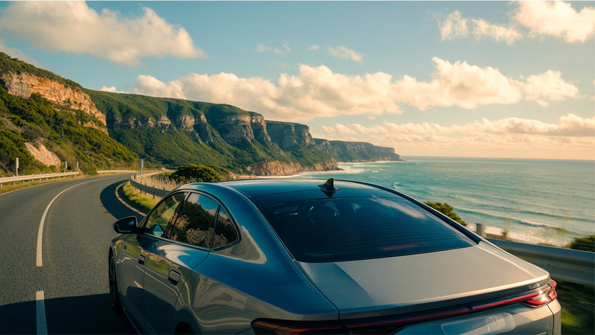 Driving a rental car along the Great Ocean Road scenic drive in Australia, highlighting coastal views for Pathfinders Travel.