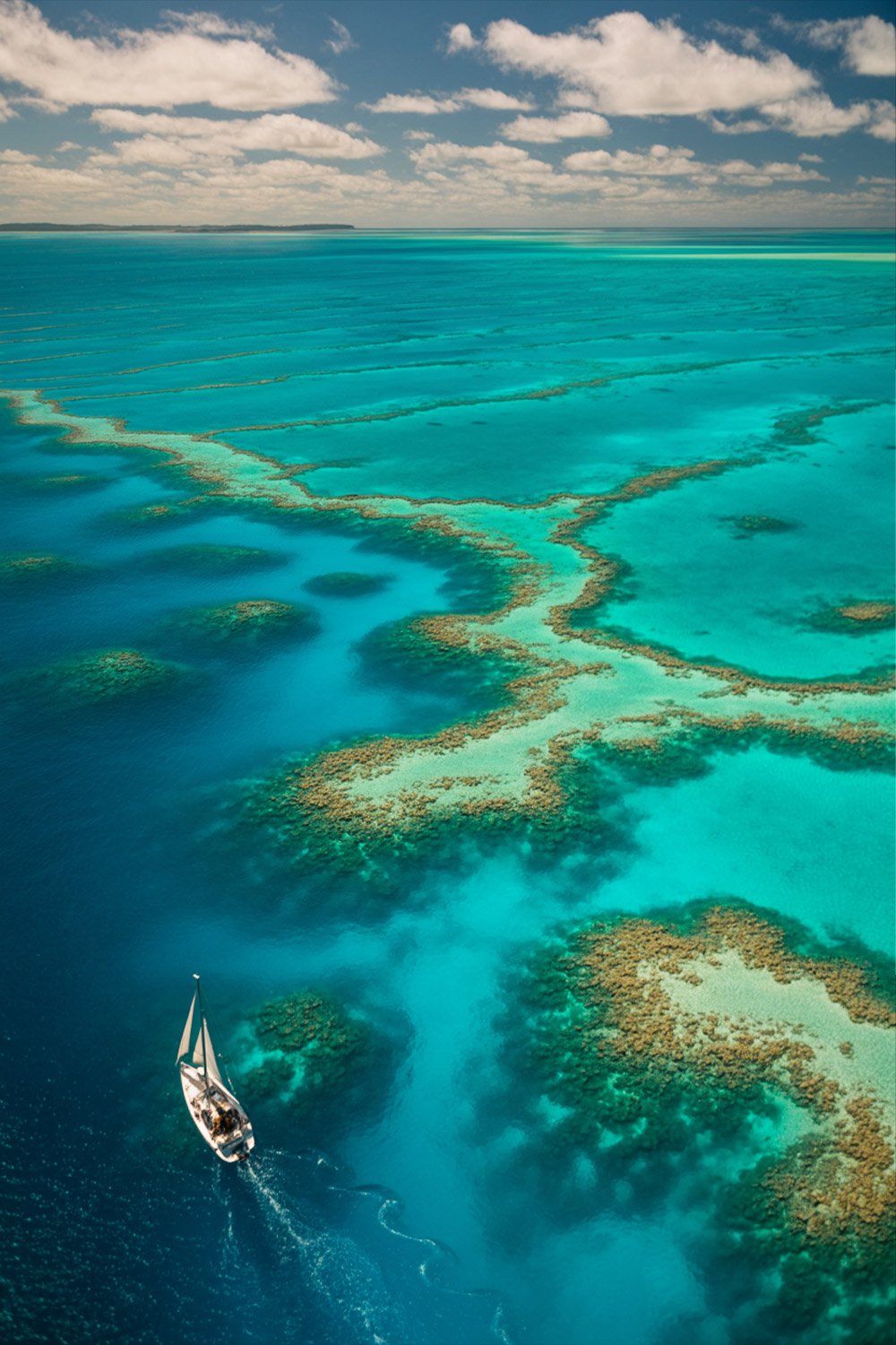 Great Barrier Reef tours aerial view from the Whitsundays, showcasing coral formations and turquoise waters in Australia