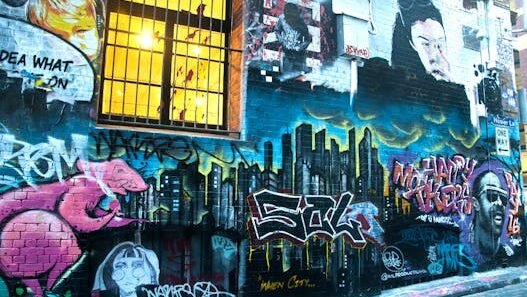 Vibrant street art covering a Melbourne laneway wall with colorful graffiti and urban imagery
