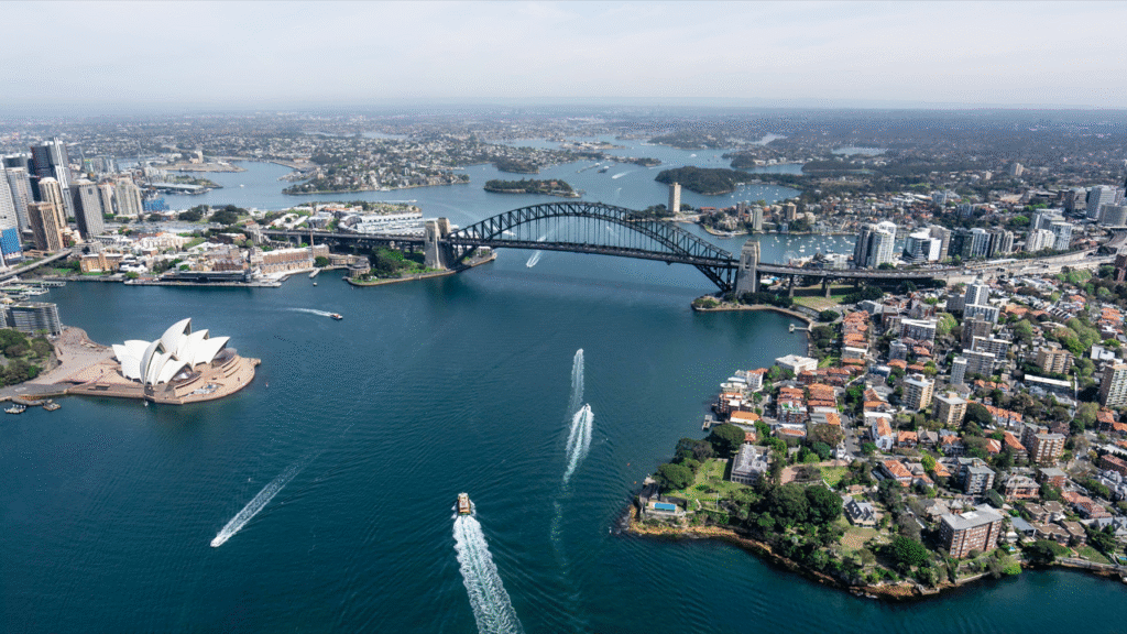 Stunning aerial view capturing Sydney Opera House and Harbour Bridge in daylight.