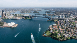 Stunning aerial view capturing Sydney Opera House and Harbour Bridge in daylight.
