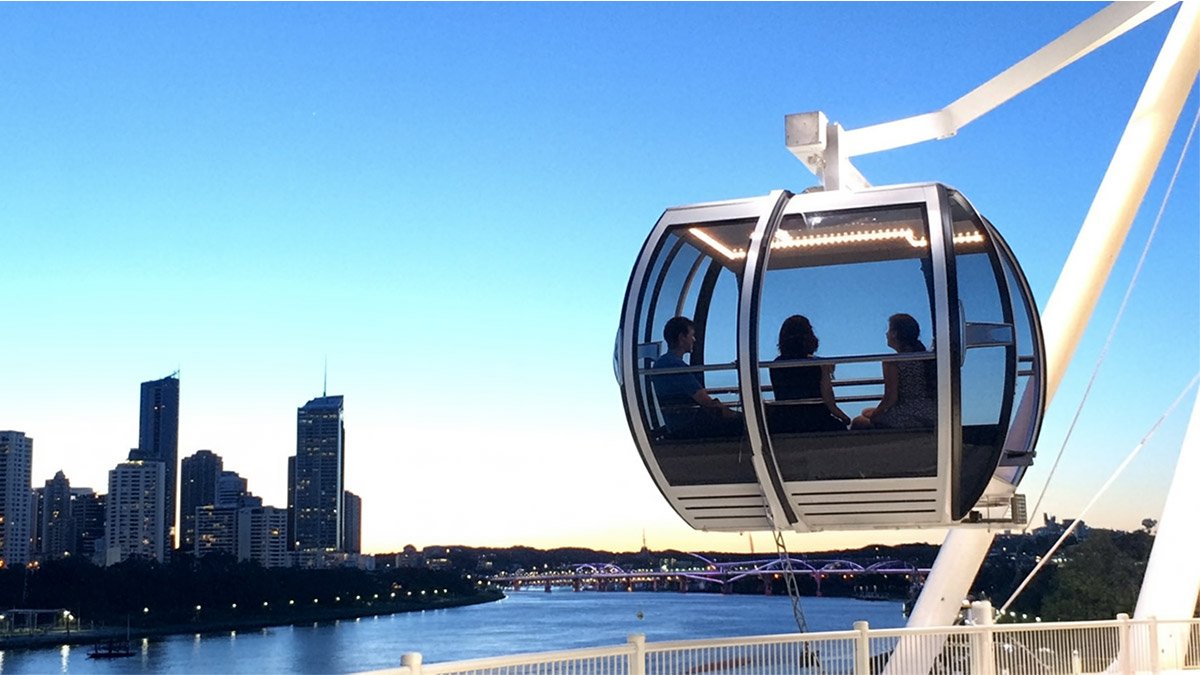 The Wheel of Brisbane illuminated at twilight, offering panoramic views of the city skyline and the river, a key attraction in Brisbane's South Bank.