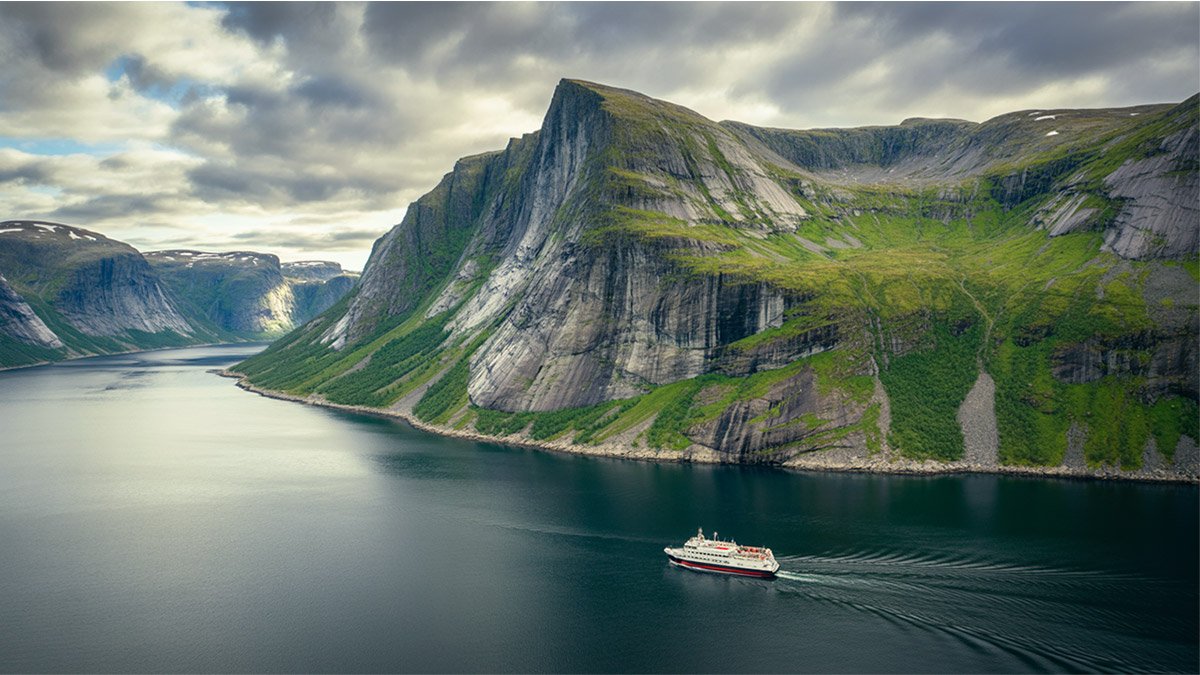 Boat tour entering Trollfjord in the Lofoten Islands, Norway, surrounded by dramatic cliffs