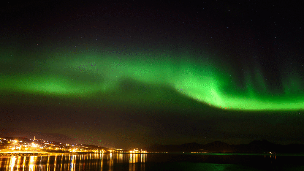 Tromsø Northern Lights Guide – vibrant green aurora borealis over snowy landscapes in Tromsø, Norway