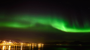 Tromsø Northern Lights Guide – vibrant green aurora borealis over snowy landscapes in Tromsø, Norway