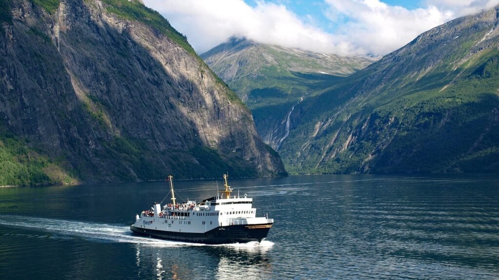 Northern lights over snow-covered peaks and Geirangerfjord waters in one of the best fjords to visit in Norway