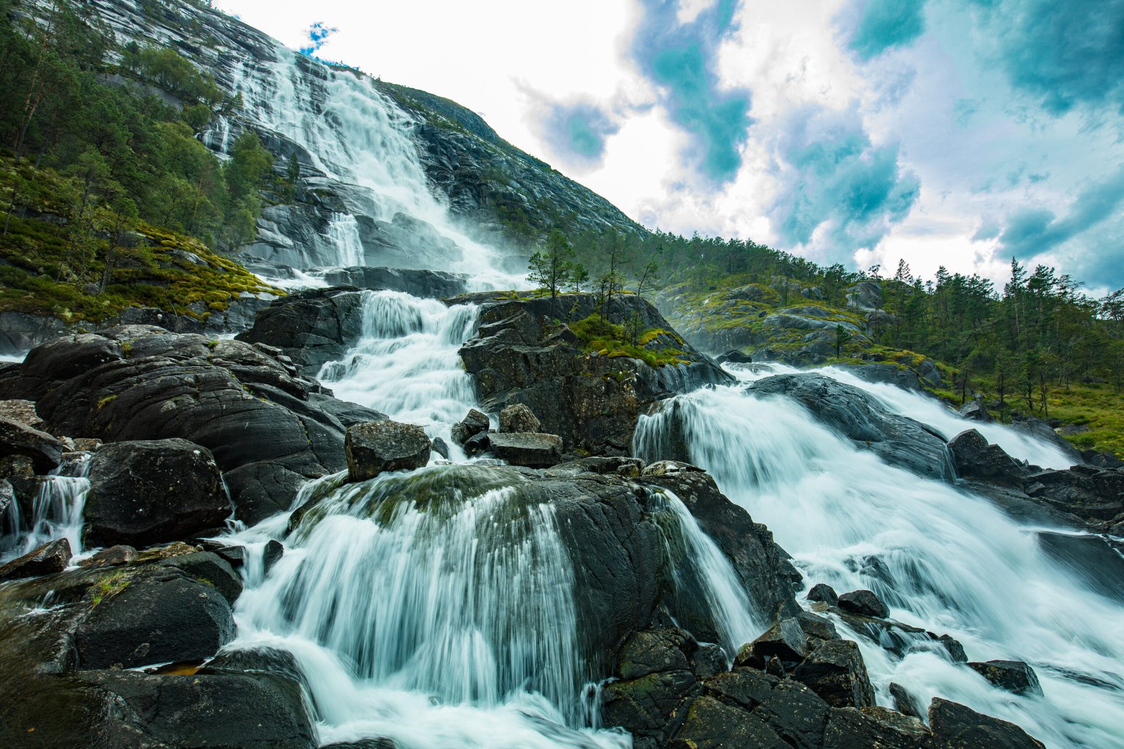 Langfossen waterfall flowing directly into Åkrafjord in Norway