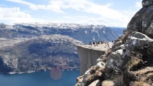Tourists enjoy the breathtaking view from the famous Preikestolen (Pulpit Rock) cliff in Norway.