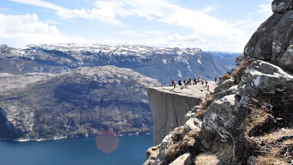 Tourists enjoy the breathtaking view from the famous Preikestolen (Pulpit Rock) cliff in Norway.