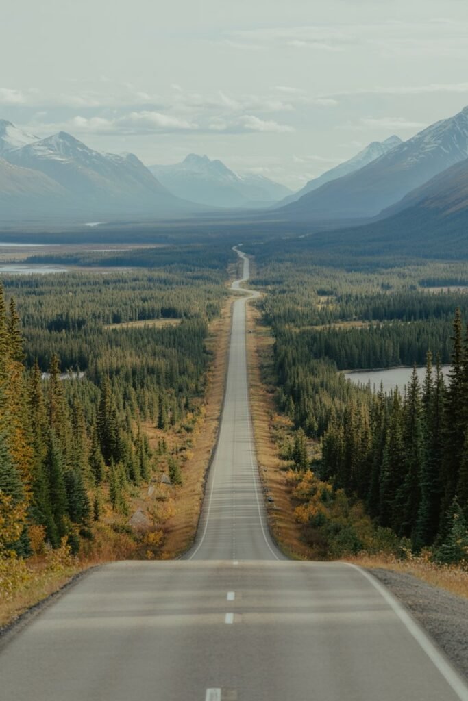 Alaska road trip on a highway surrounded by mountains, illustrating affordable travel options and Alaska vacation cost savings with Pathfinders Travel