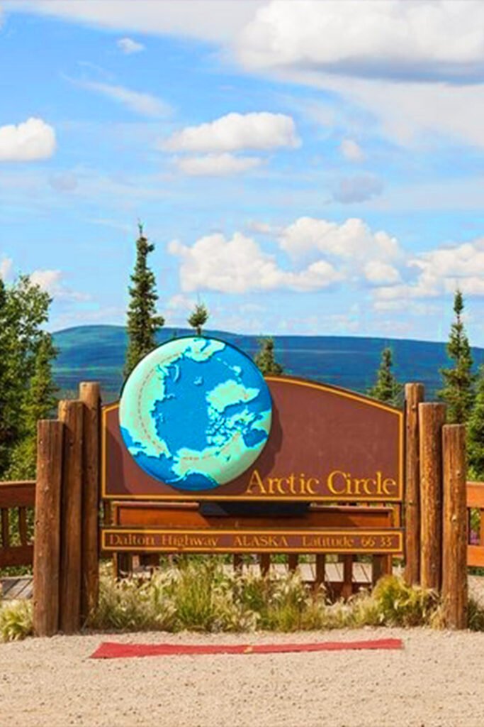 Arctic Circle Monument along the Dalton Highway Alaska, featuring the famous wooden sign marking latitude 66°33′ North — a key stop for Arctic Circle tours from Fairbanks documented by Pathfinders Travel.