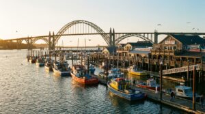 Newport Oregon bayfront with fishing boats and Yaquina Bay Bridge at golden hour