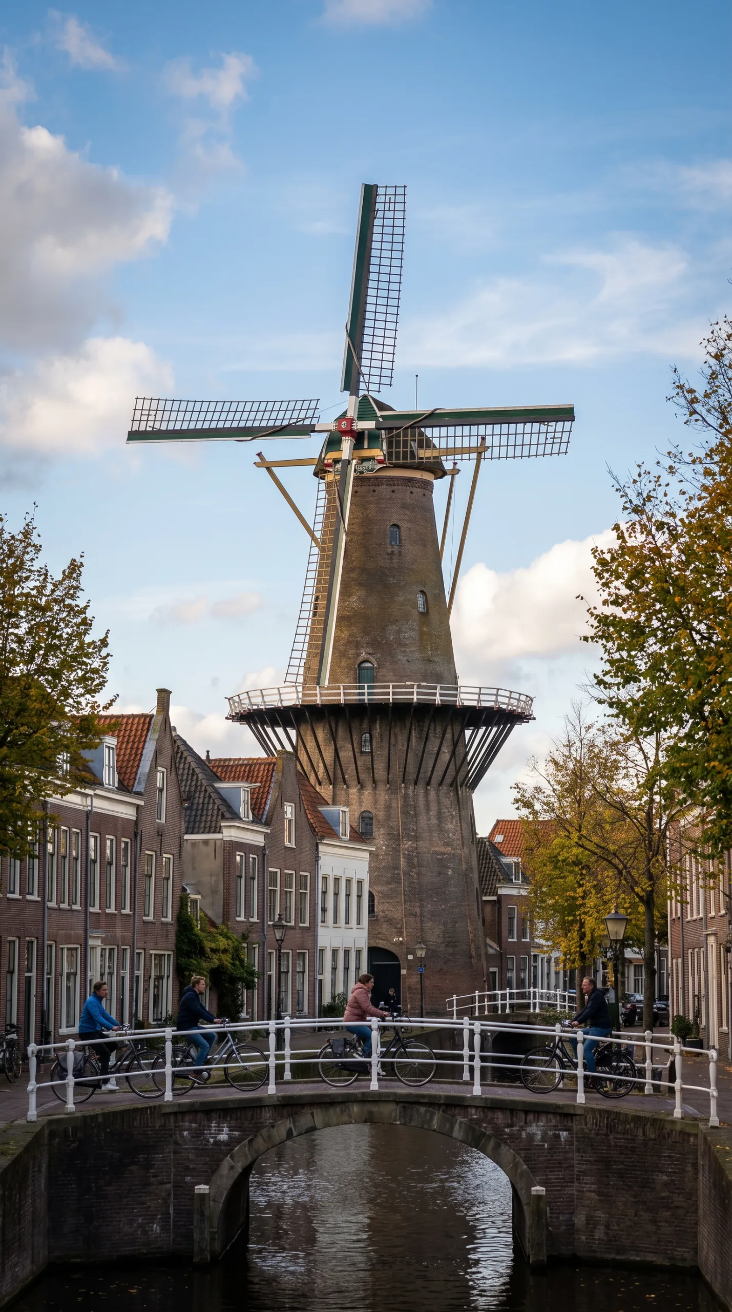 De Valk windmill museum tower rising over a canal in central Leiden